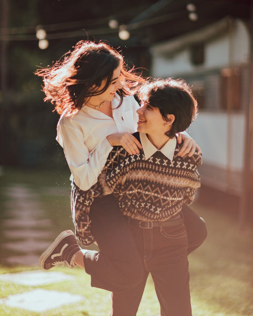 Who We Serve 6 Enamored young ethnic teen female in trendy outfit giving piggyback ride to cheerful girlfriend while spending time together in park on sunny day